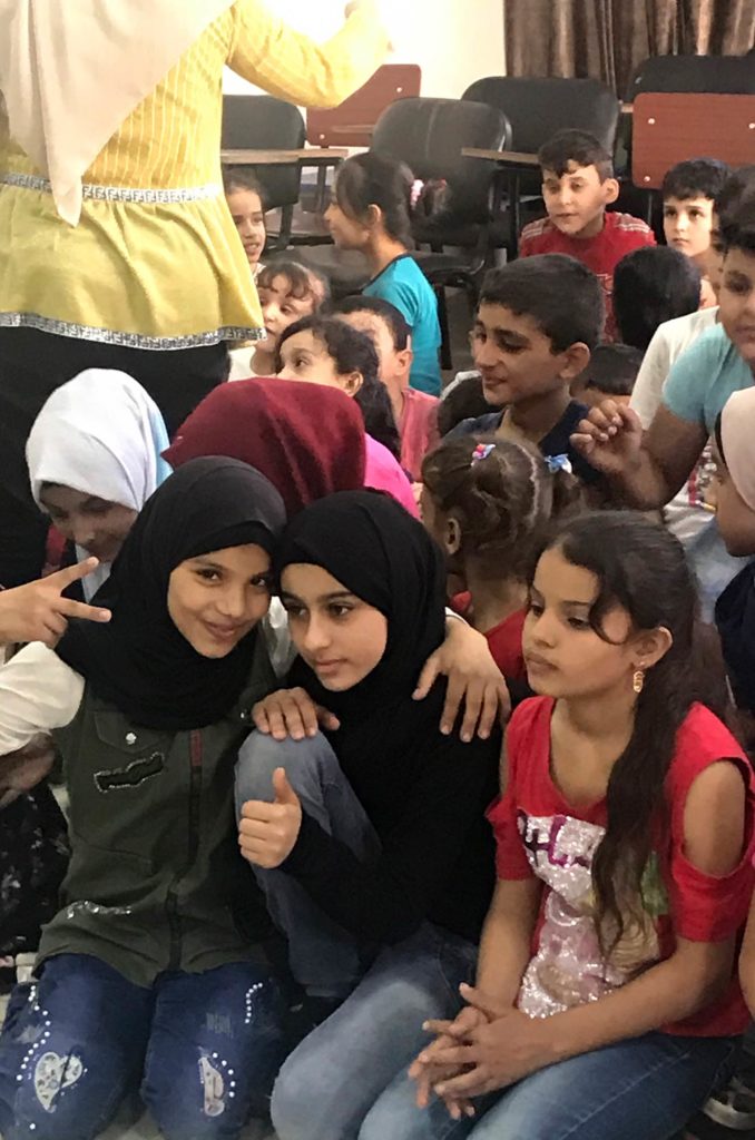 Children in Burj El Barajneh await their new backpacks.