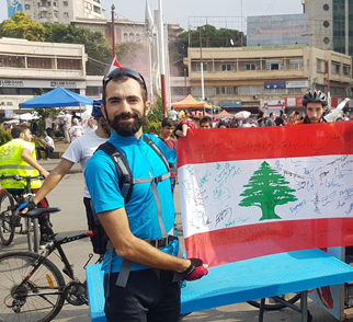 Natheer Halwani at a protest in Tripoli with a Lebanese flag.