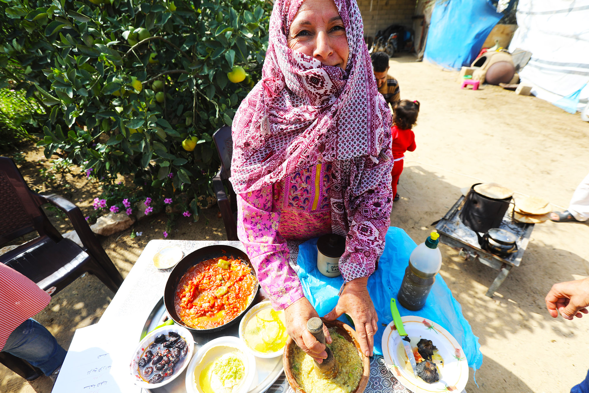 Wael’s mother, Samira prepares a meal of fried tomatoes, baba ghanouj and cucumber salad from their first harvest.
