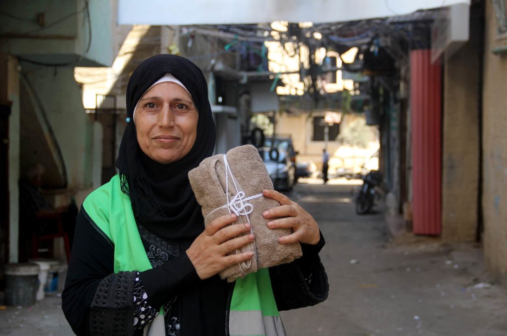 Samira holding a sample hygiene kit in Burj El Barajneh Palestinian Refugee Camp, Lebanon.