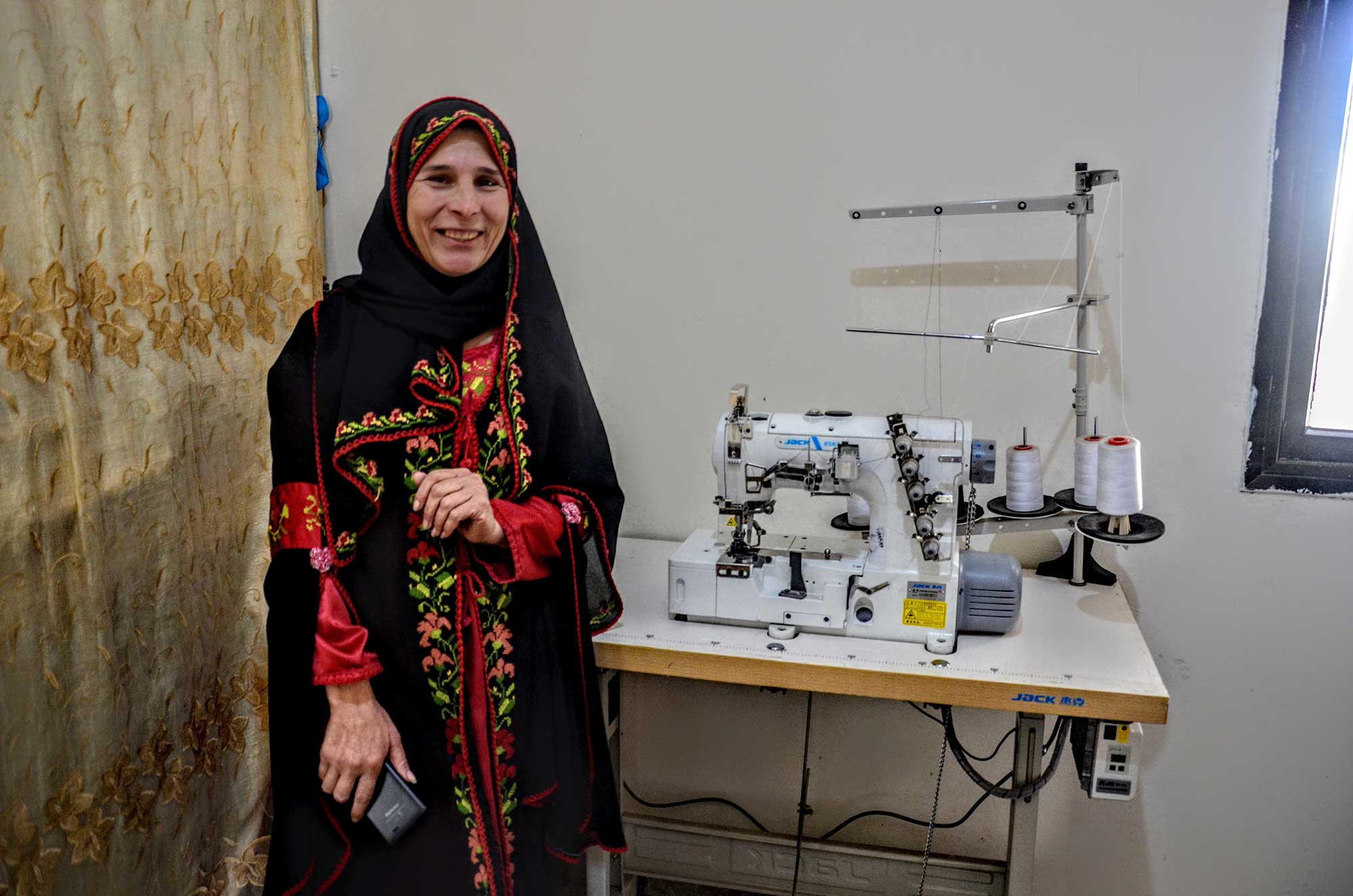 Palestinian dressmaker Asmaa with her new sewing machine from Anera