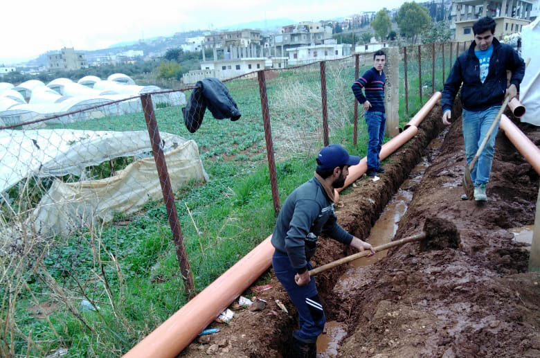 In preparation for winter, graduates from Anera's course on plumbing install a water network at Rihaniye Syrian refugee camp in Lebanon.