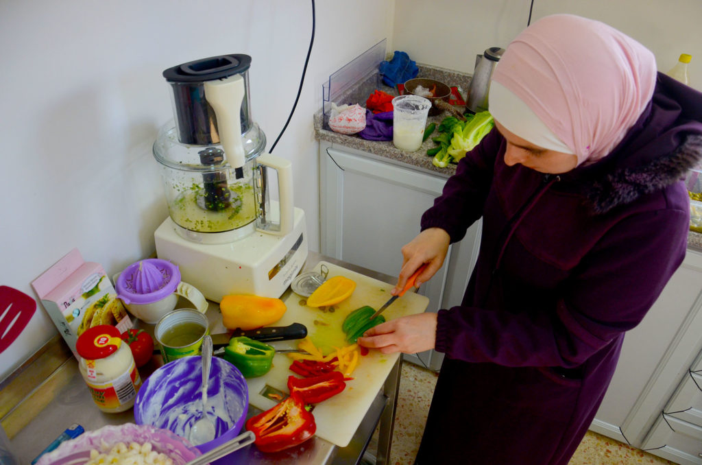 Kholood cuts up peppers for the meal she is preparing in her new kitchen.