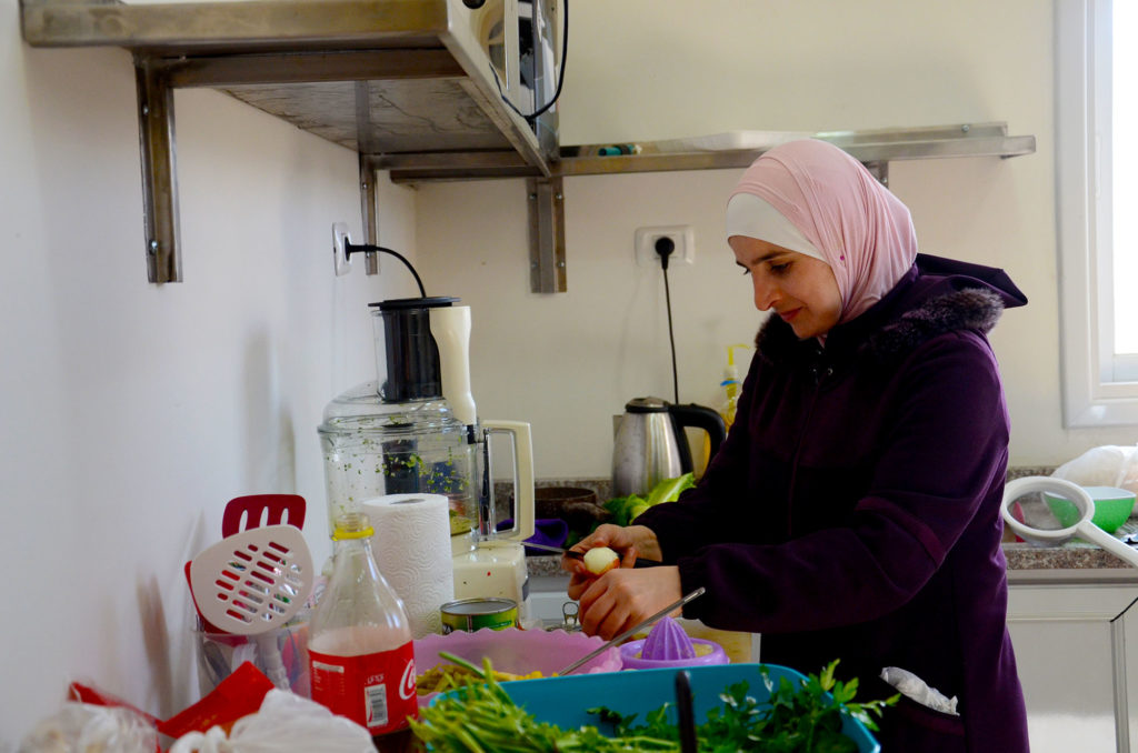 Kholood prepares ingredients in her new kitchen, thanks to Anera's Women Can program.