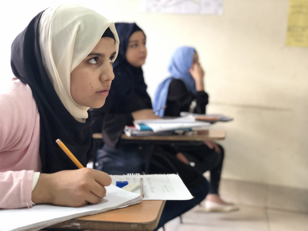A group of earnest English learners work on exercises at the Nour Center, Anera's partner in Burj El Barajneh Palestinian refugee camp in Lebanon.
