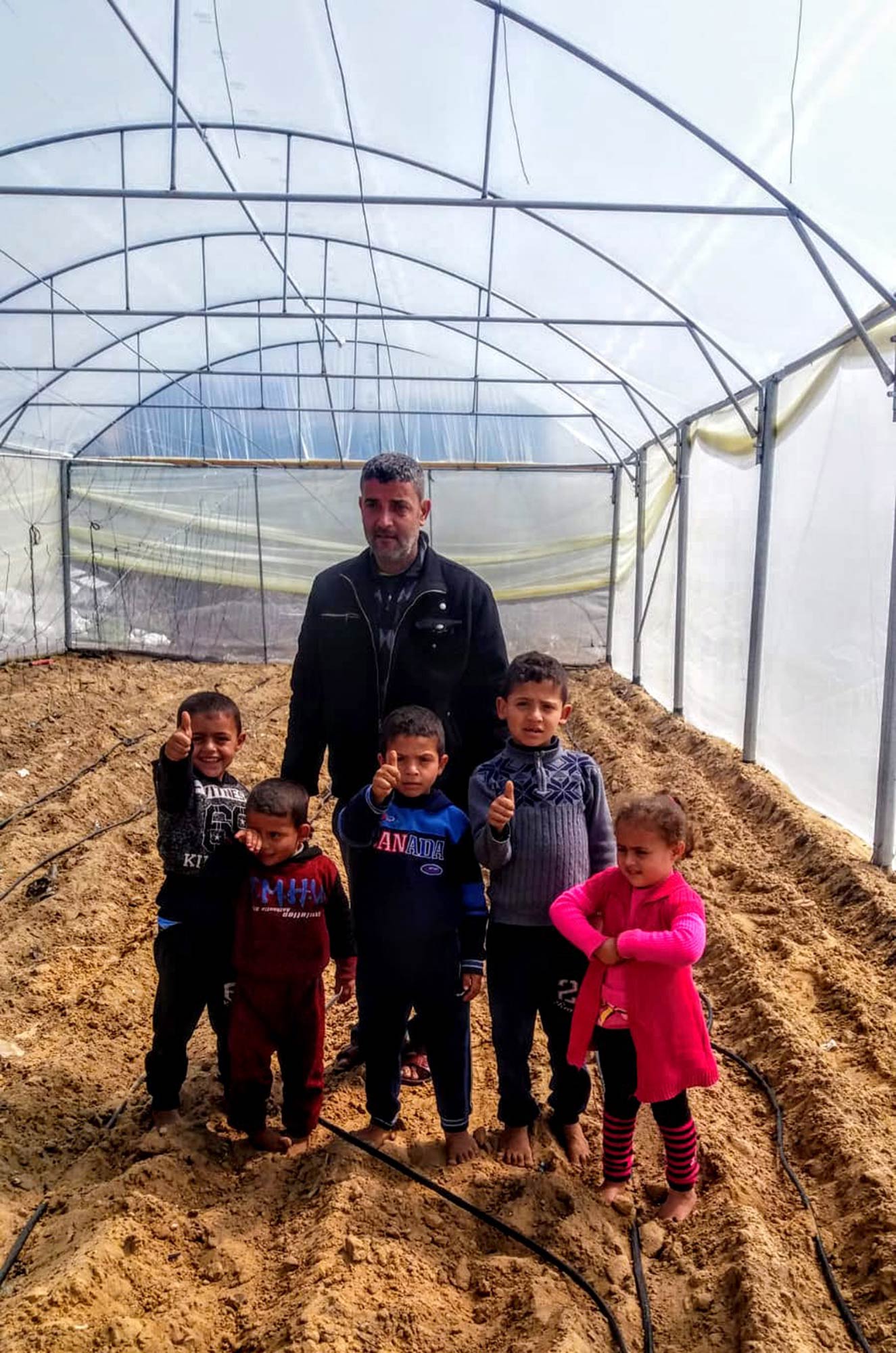 The Joudah family in their new greenhouse in Rafah, Gaza.