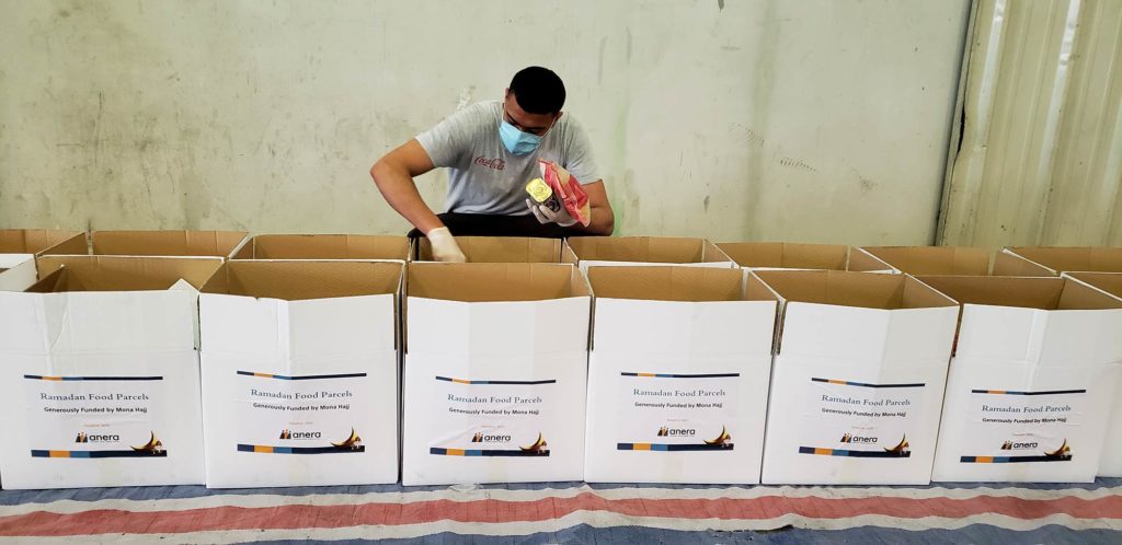 A worker puts food items into each box