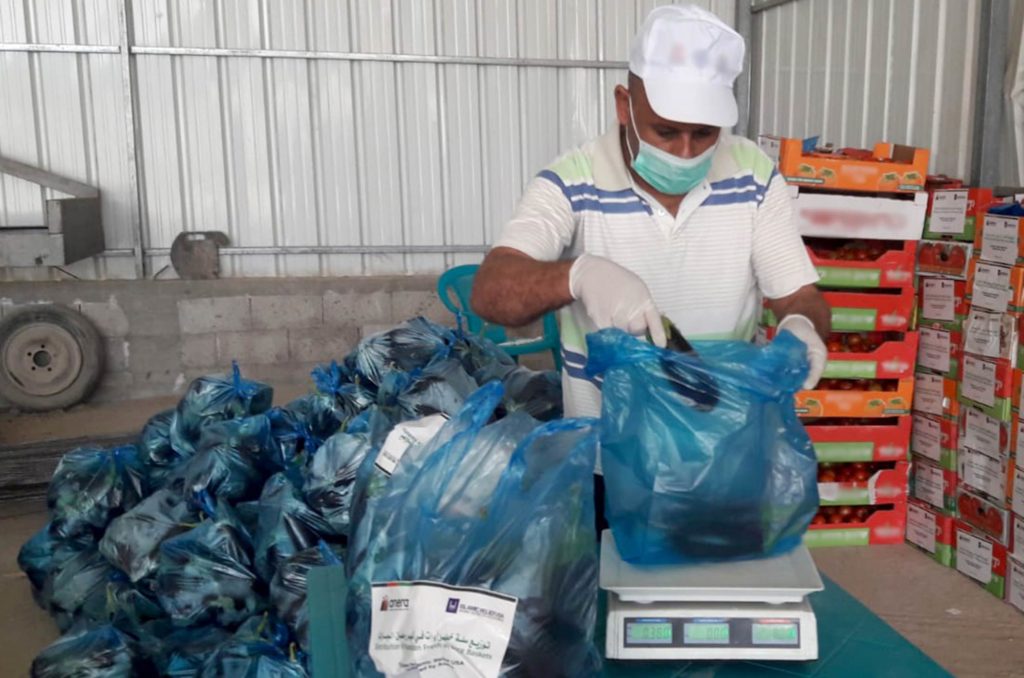 A worker weighs bags of eggplants for our Ramadan food parcels in Gaza, Ramadan 2020.