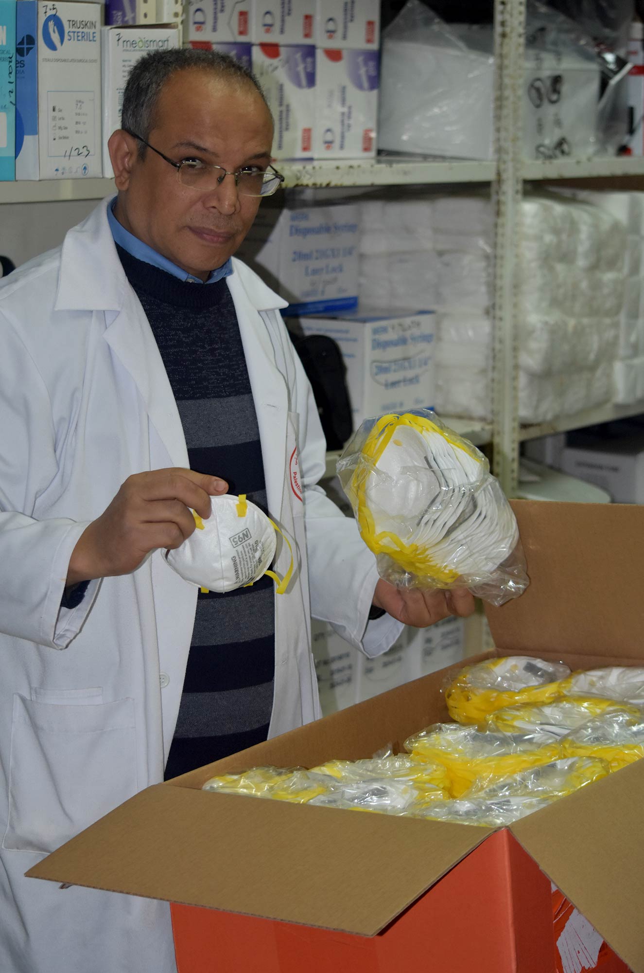 Jamal Maarouf, a nurse at Haifa Hospital, inspects the shipment of N95 respirator masks.