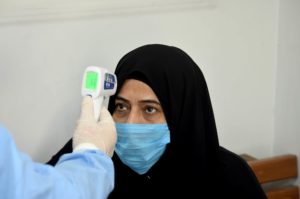A nurse reads a patient's temperature at Haifa Hospital.