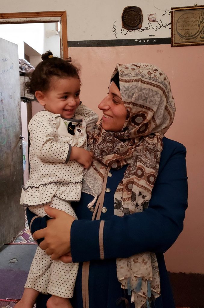 Rahma with one of her children at their small house in the Zeitoun neighborhood of Gaza.