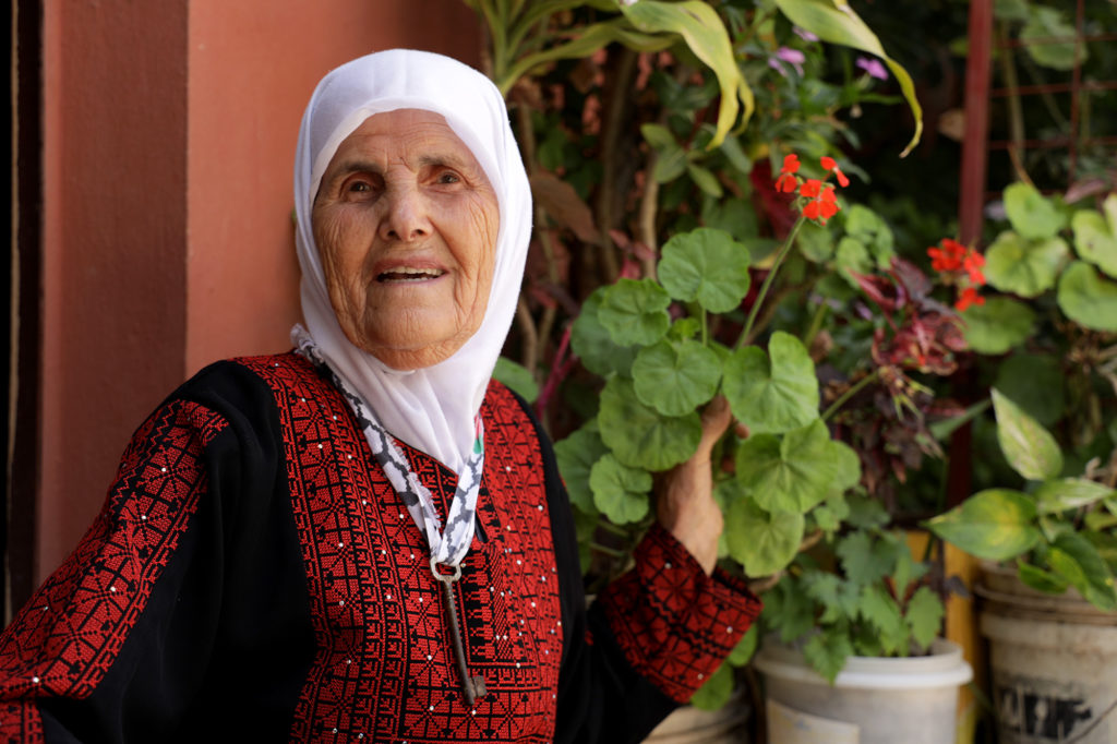 Aisha in front of her home.