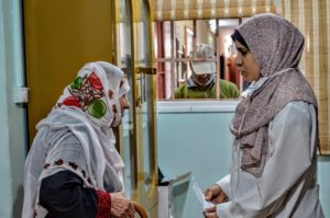 Marwa, a pharmacist at the clinic, speaks with a patient.
