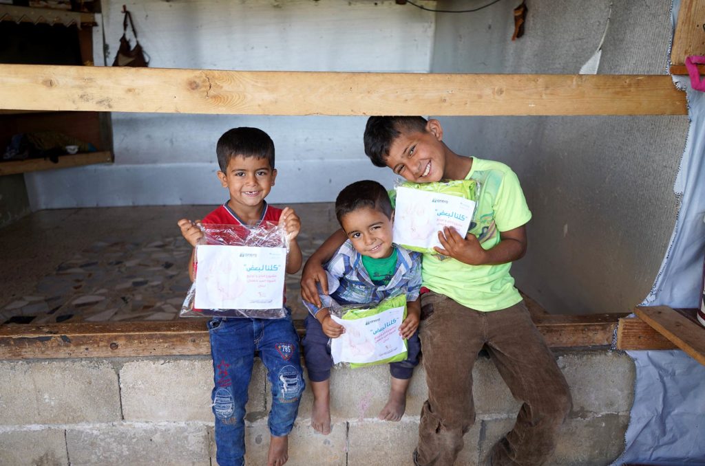 Umm Nasser’s sons hold the packets with their new clothes.