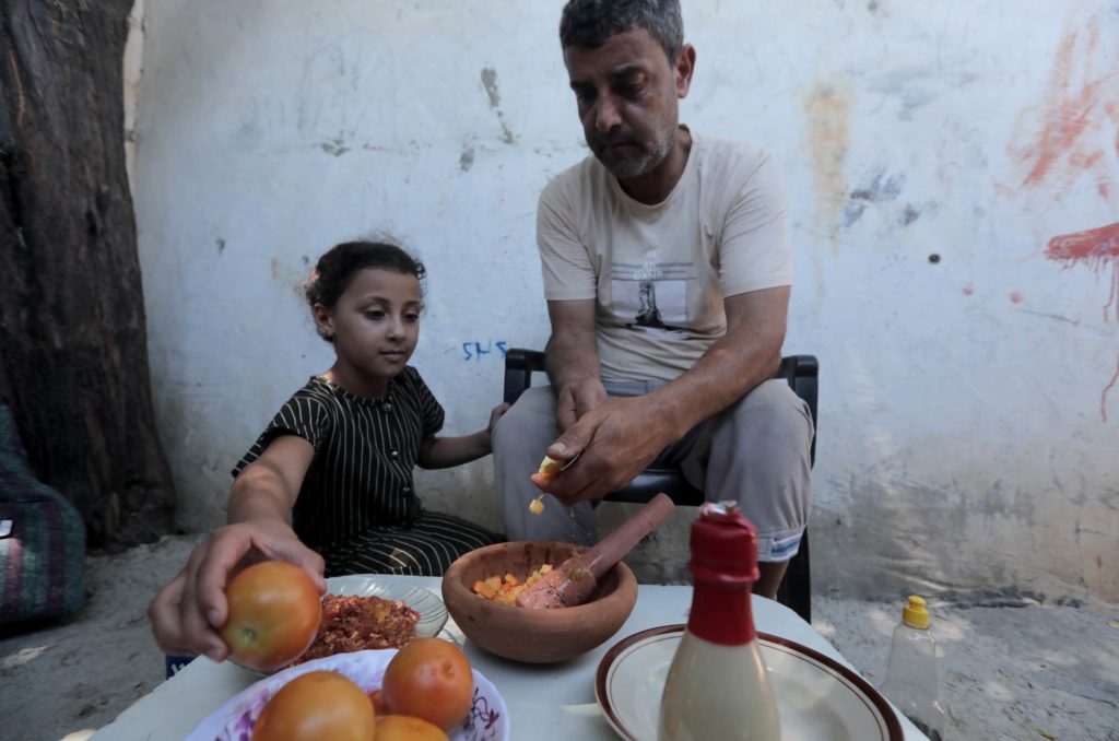 Gaza, Rafah, greenhouses, harvest, food, enjoying a snack Mahmoud and his daughter prepare a snack with tomatoes from their greenhouse