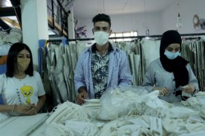 Three youths making face masks.