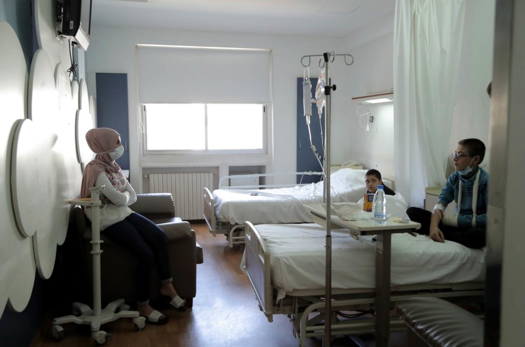 Lebanon, medical-aid, chemotherapy, Makassed General Hospital A woman visits with a young patient.