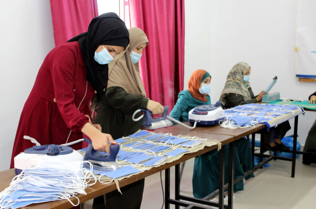 Women at CSSL press the cloth face masks.