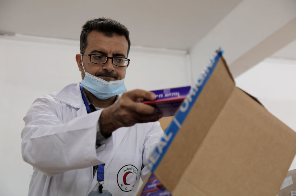 Dr. Abu Qamar pulls a packet of bortezomib out of the box.