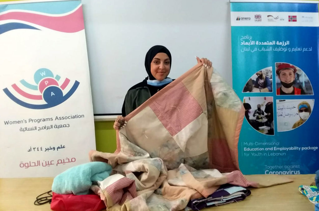 Relief, blankets, Lebanon, Burj-El-Barajneh, Lutheran-World-Relief, Women's-Programs-Association Holding up one of the blankets being distributed to families in need.