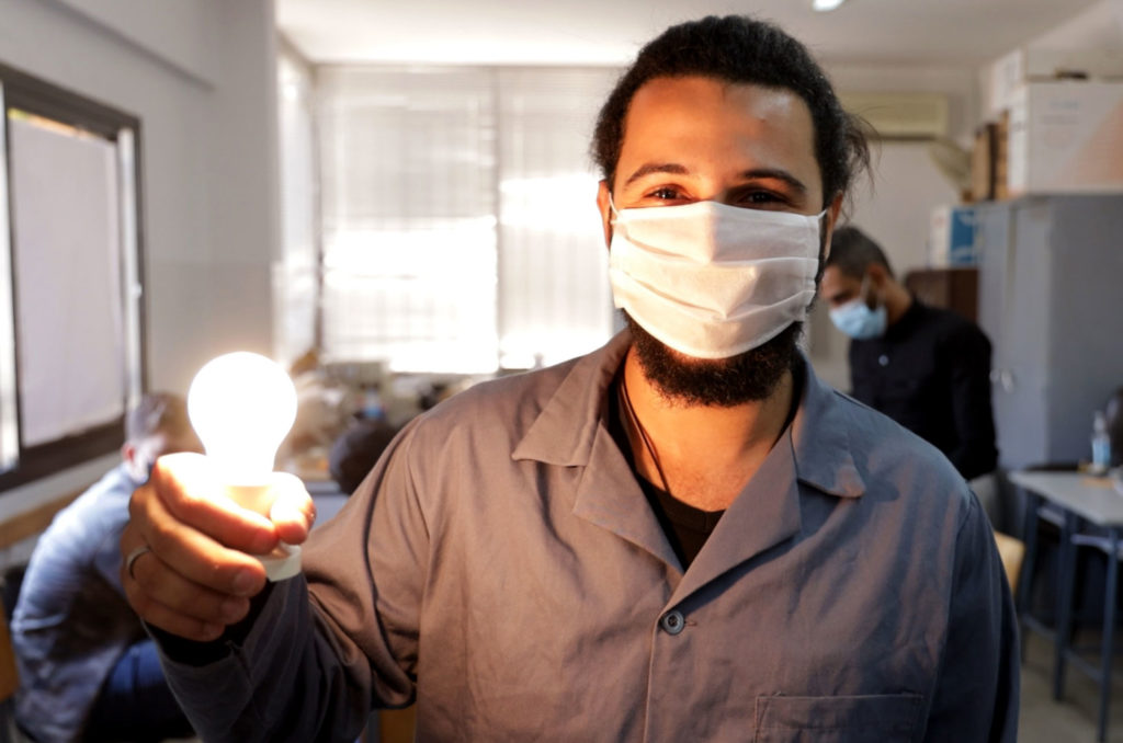 vocational, education, Lebanon, Saida, electrical, light-bulb A student holds up a glowing light bulb.