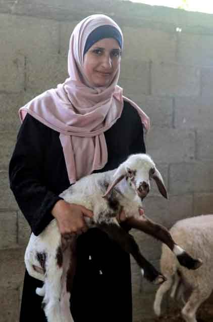 Asma holds a lamb she is raising in Beit Hanoun, Gaza.