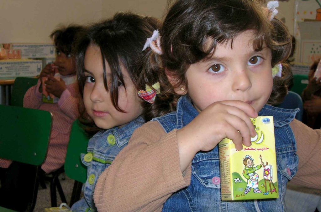 A preschooler in the Jabalia Palestinian Refugee Camp in Gaza enjoys her vitamin-rich snack from Anera.