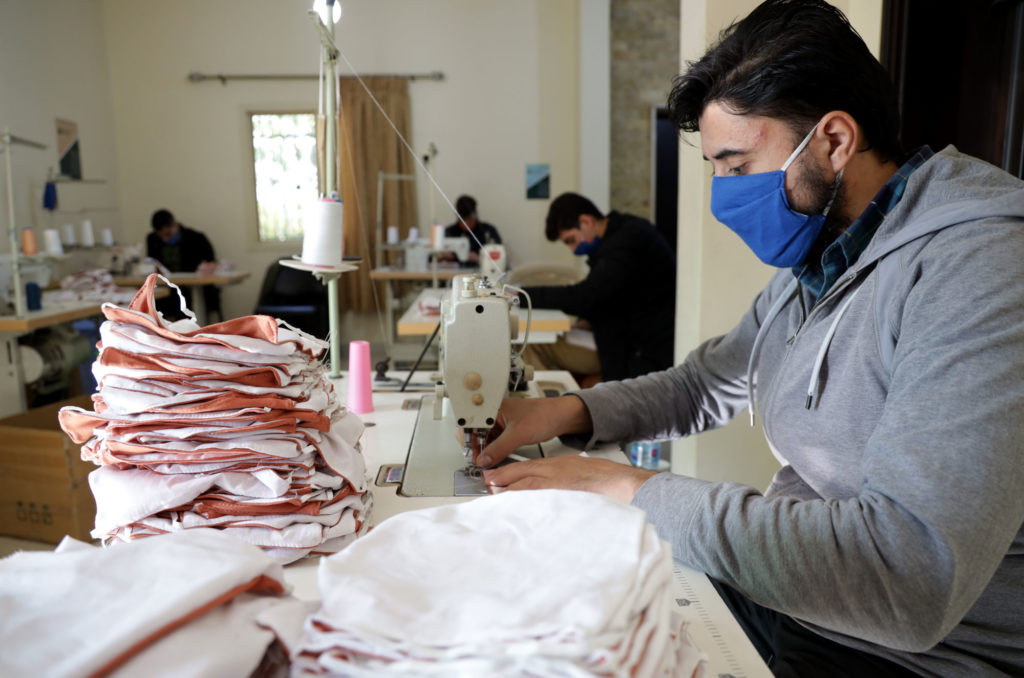 Sewing jobs skills training student at his machine making masks