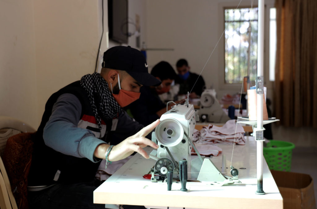 Sewing course student works his machine