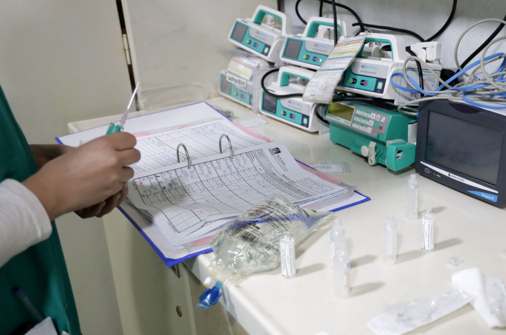 A hospital staffer sets out some unpacked donated vials of medicines and syringes.