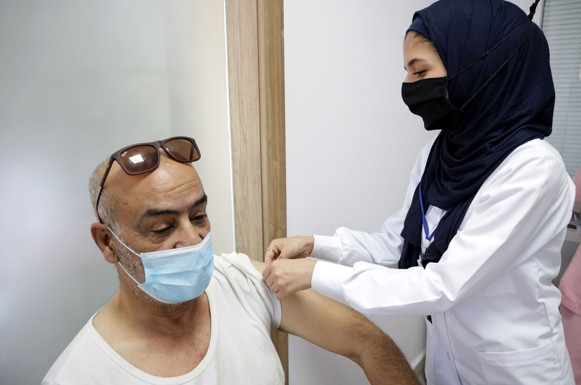 An Anera nursing student works with a patient in Tyre, at the Sadr Foundation.