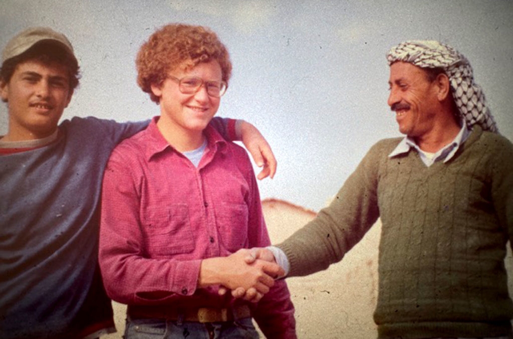 Scott Lecrone posing for a photograph with Abu Mustafa and his son.