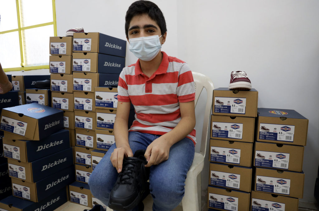 A boy tries on his new shoes, thanks to a donation by UNICEF.
