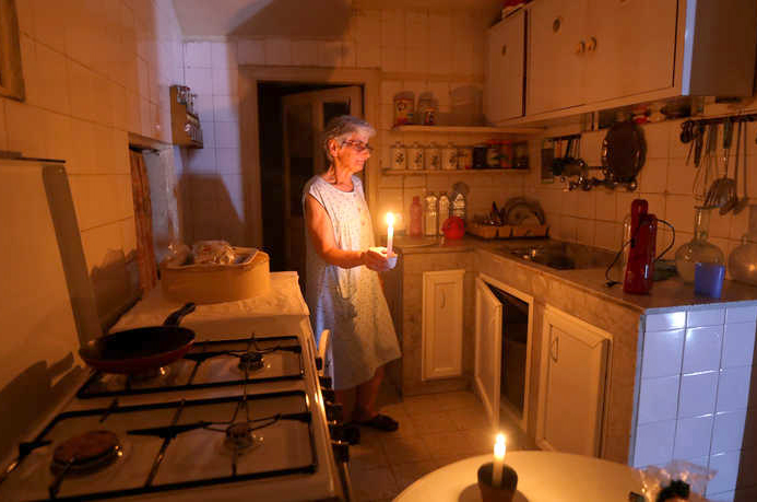 Samira uses a candle in her Beirut apartment, because she has no power.