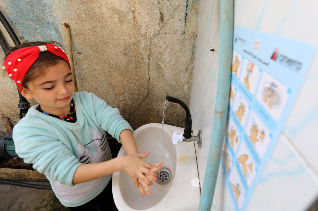 Iman’s niece washes her hands following Anera’s hygiene guidelines.