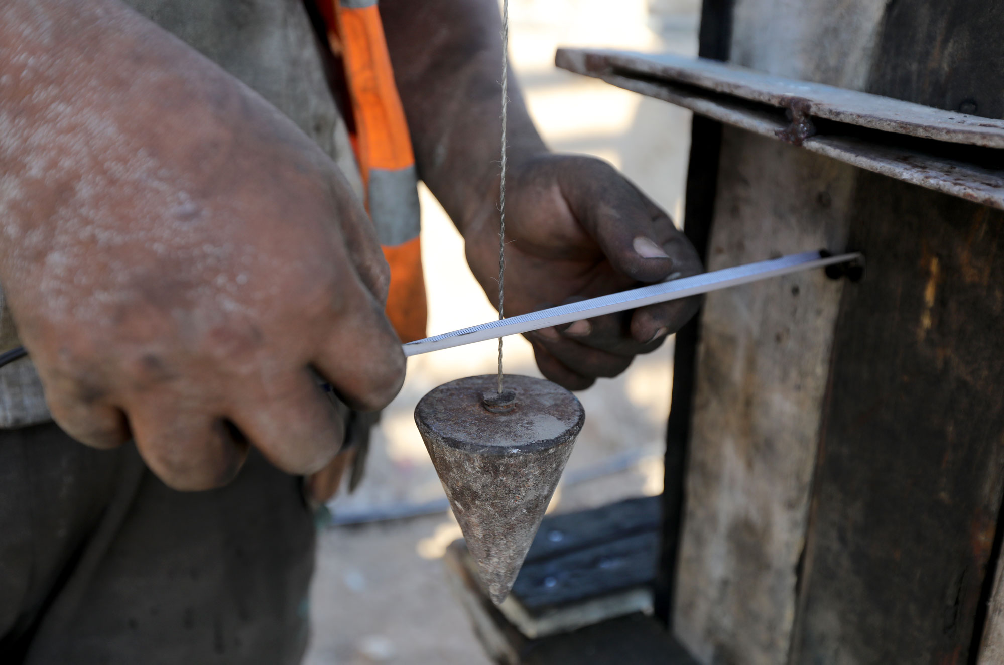 Closeup of measuring a plumb bob.