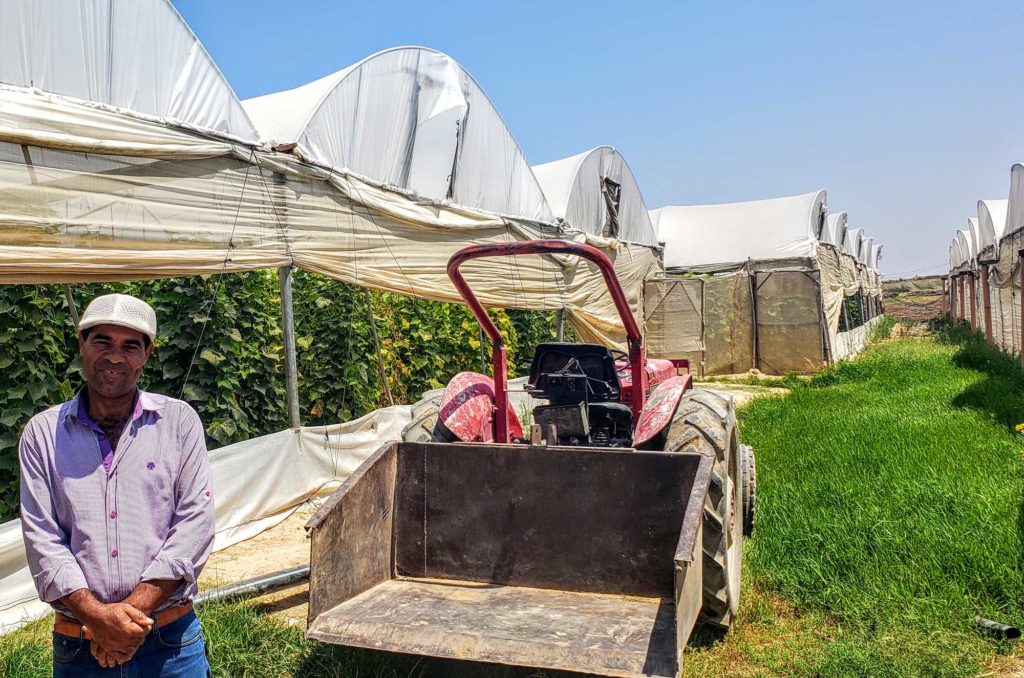 a farmer in front of his greenhouse in Gaza