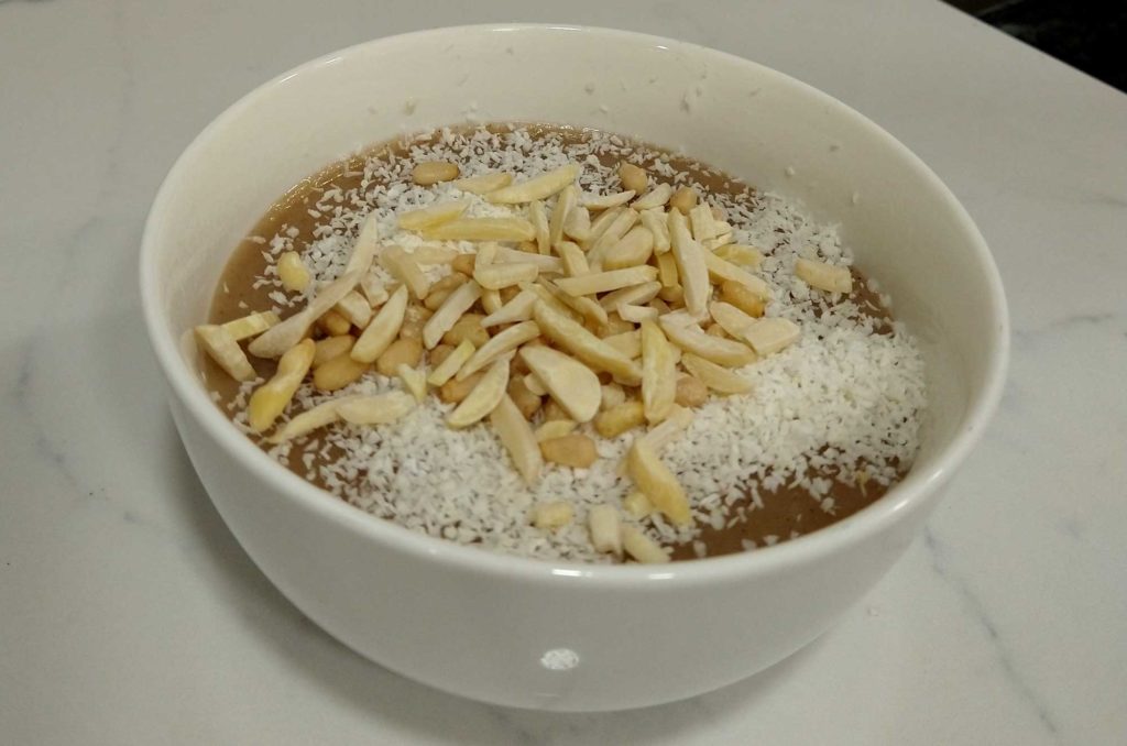 A fresh bowl of Palestinian mughli, garnished with coconut and pine nuts