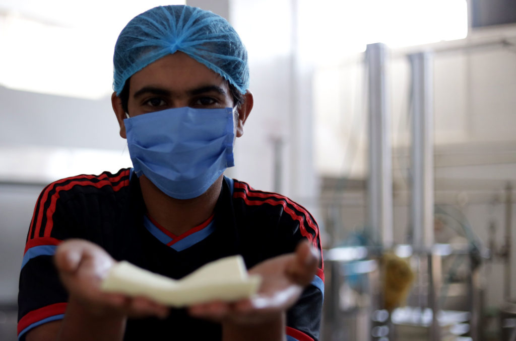 Omar holds up fresh cheese.