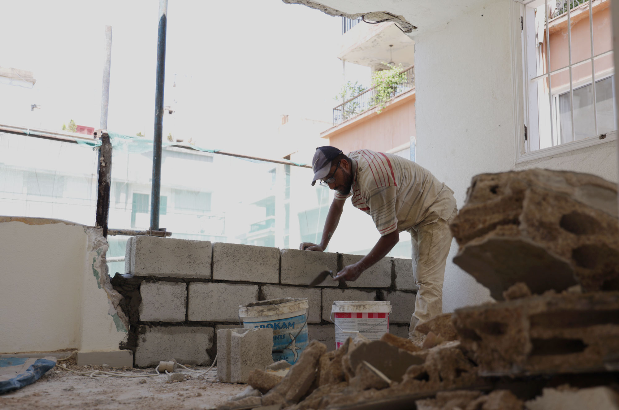 Workers repairing walls inside a Gemmayze apartment building