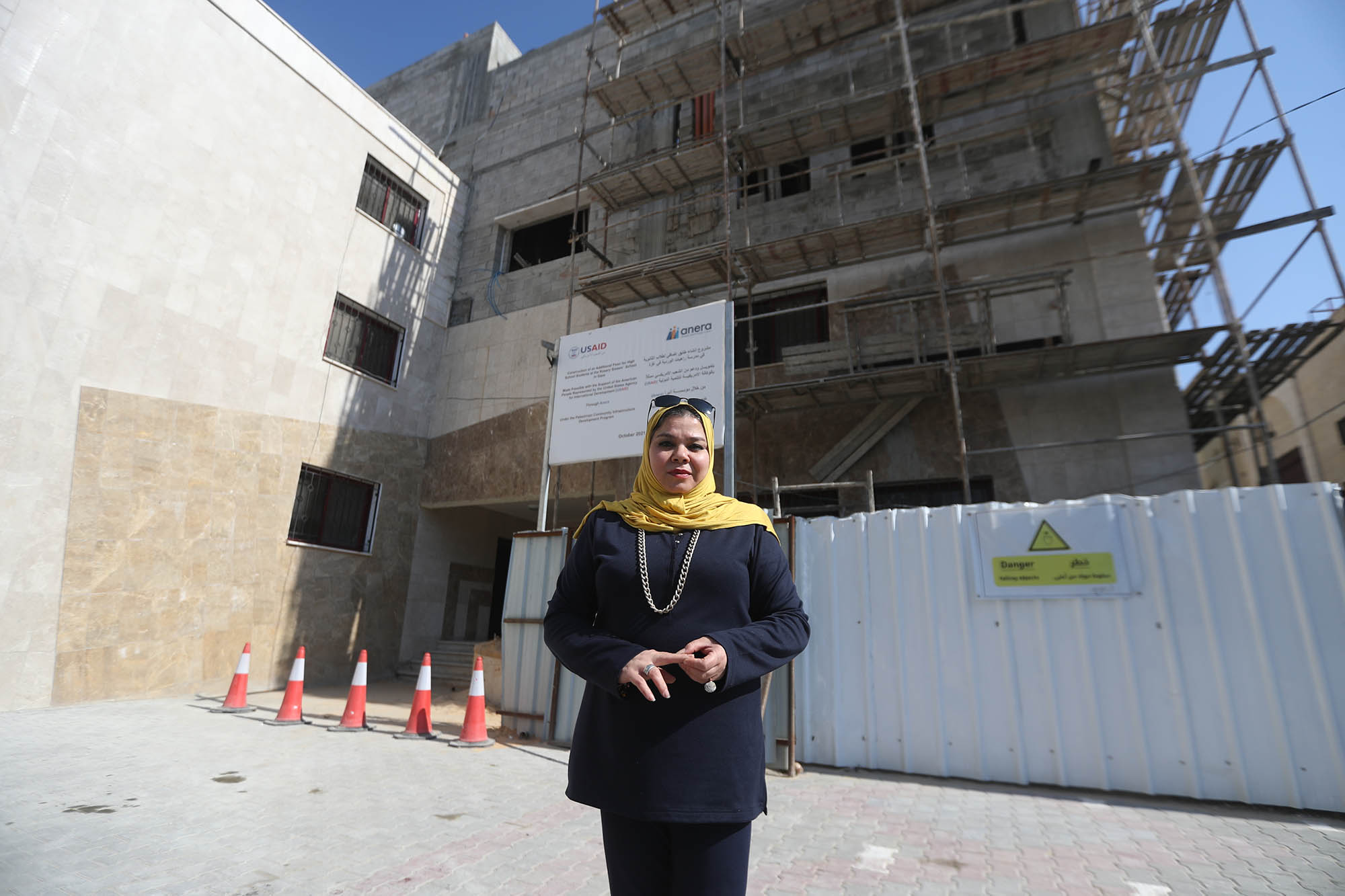 Ms. Abu Motlek standing in front of the ongoing USAID-funded Anera construction of the new Rosary Sisters School addition.