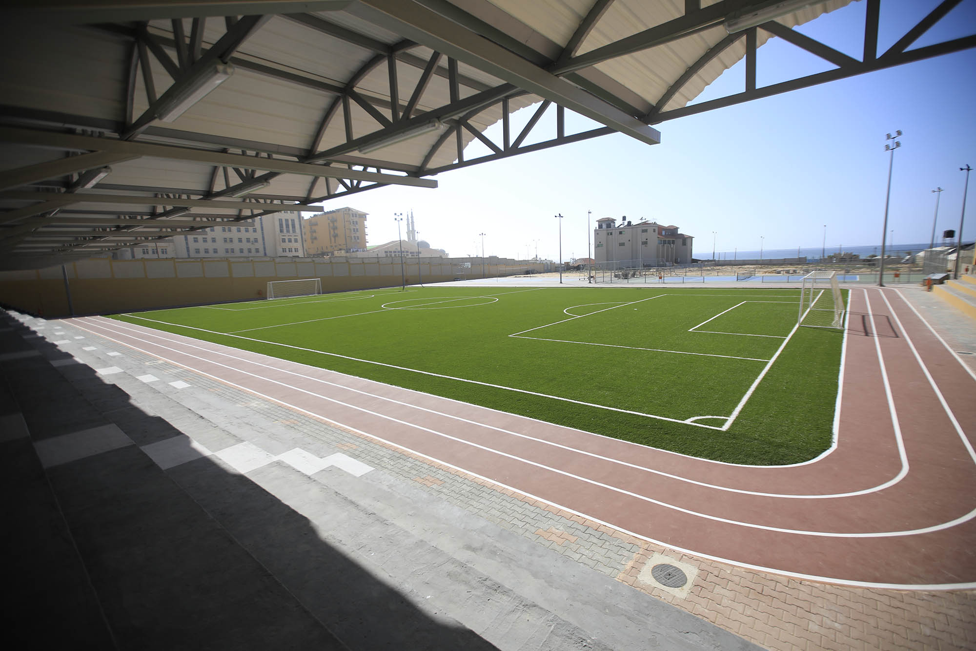 The track and stadium seating around the football field at the Gaza sports club.