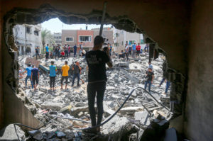 Crowd inspects the rubble in Gaza.