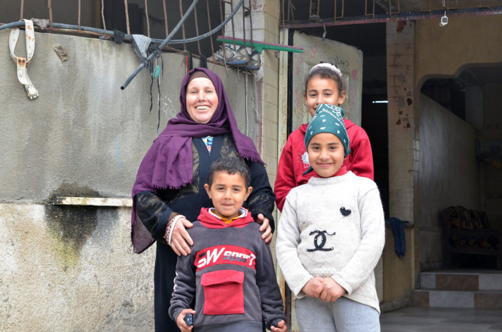 Amal with three of her children outside their home.