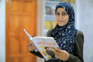 Teacher reading from a book at the new Unlimited Friends Association building in Gaza