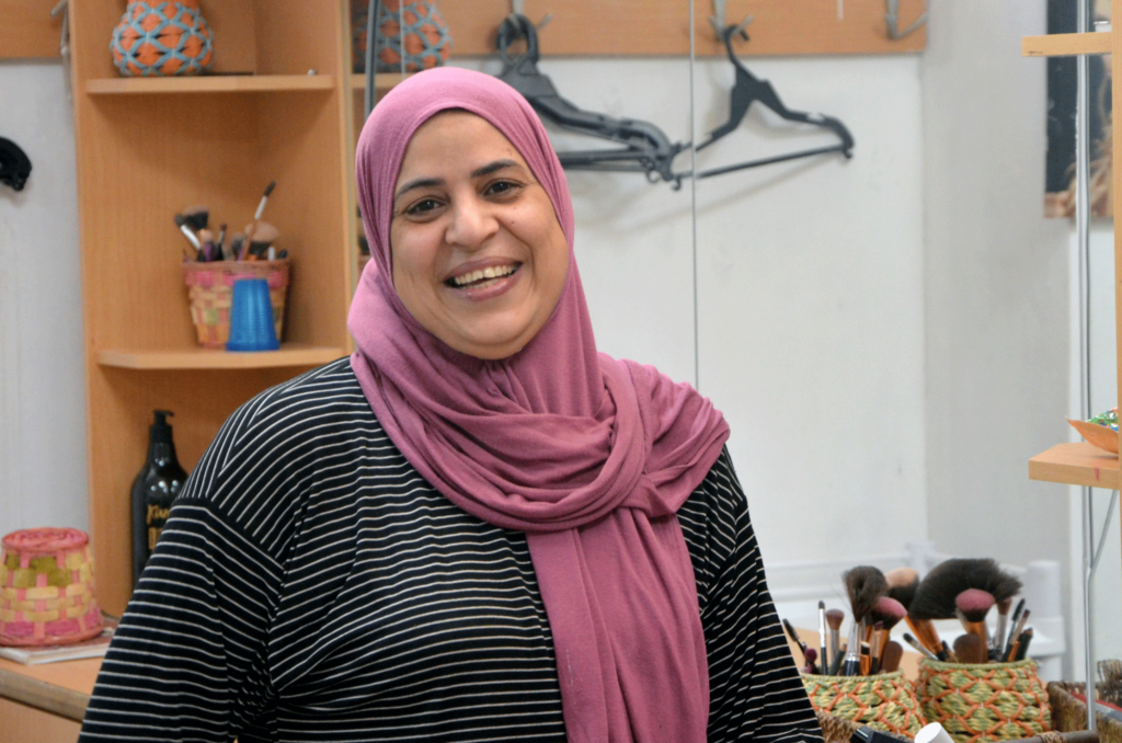 Fayrouz grins at a the camera in her salon.