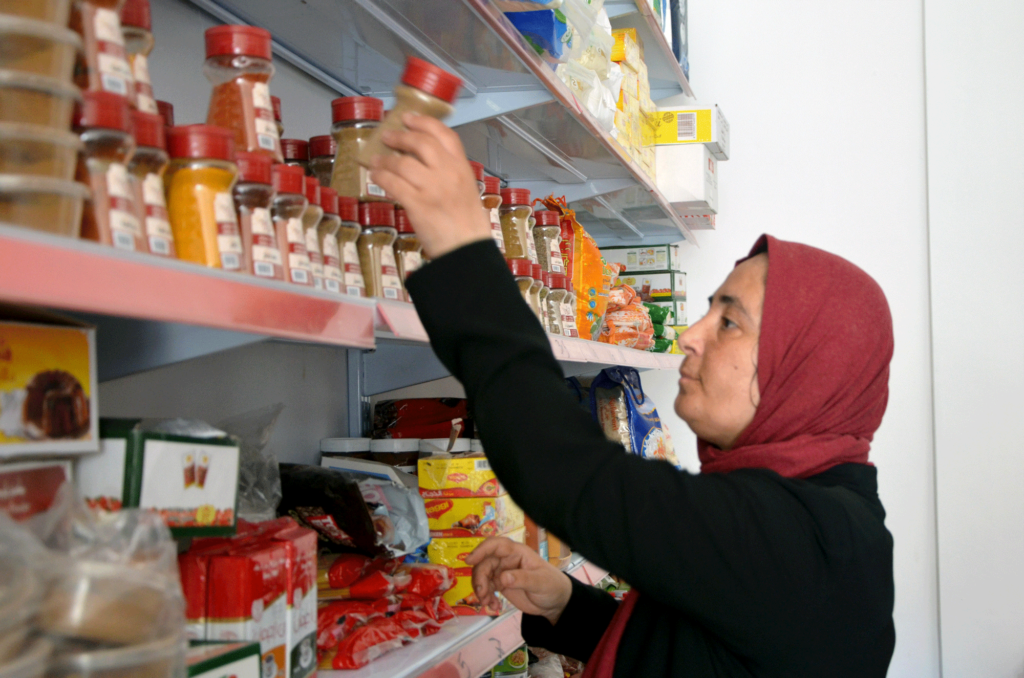 Kawthar stocks the shelves of her store