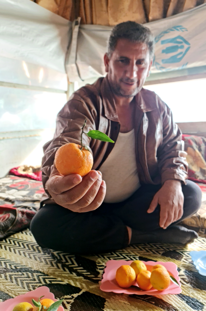 Abdelrazzak holds up an orange.