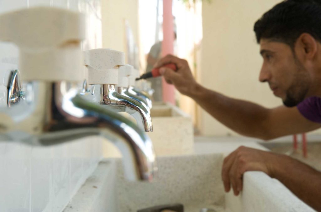 Preschool-Rehabilitation-Deir-Al-Balah-Gaza An Anera contractor installs new faucets at the Atufula Al Mubakera primary school in the Deir Al Balah refugee camp in Gaza. 2010.