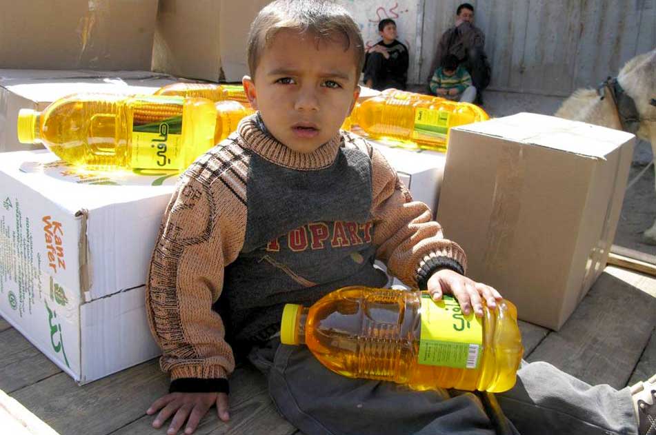 Rafah-food-distribution A youngster sits on his family's cart amidst the food items they just received from Anera.